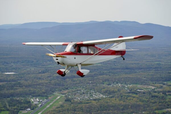 Picture of a red and white Aeronca Champ in flight